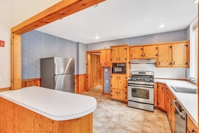 54 Harris Street, Unit 54 Acton, MA 01720 - Photo 3 of 9 a kitchen with stainless steel appliances granite countertop a stove a refrigerator and a sink
