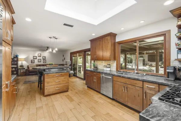 a living room with furniture a flat screen tv and kitchen view