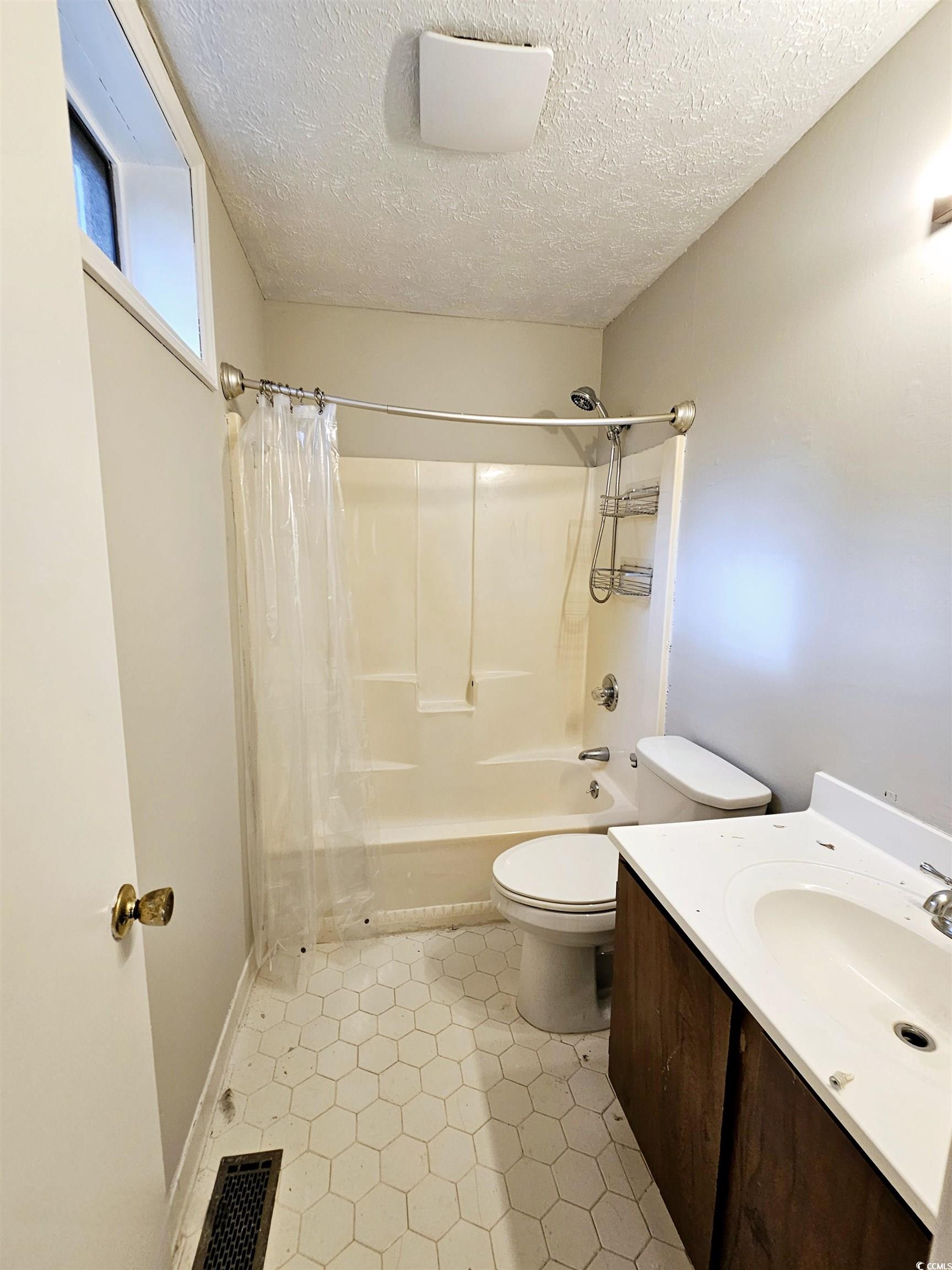117 Partridge Berry Road Myrtle Beach, SC 29579 - Photo 21 of 33 Full bath featuring vanity, shower / tub combo with curtain, a textured ceiling, and light tile patterned floors