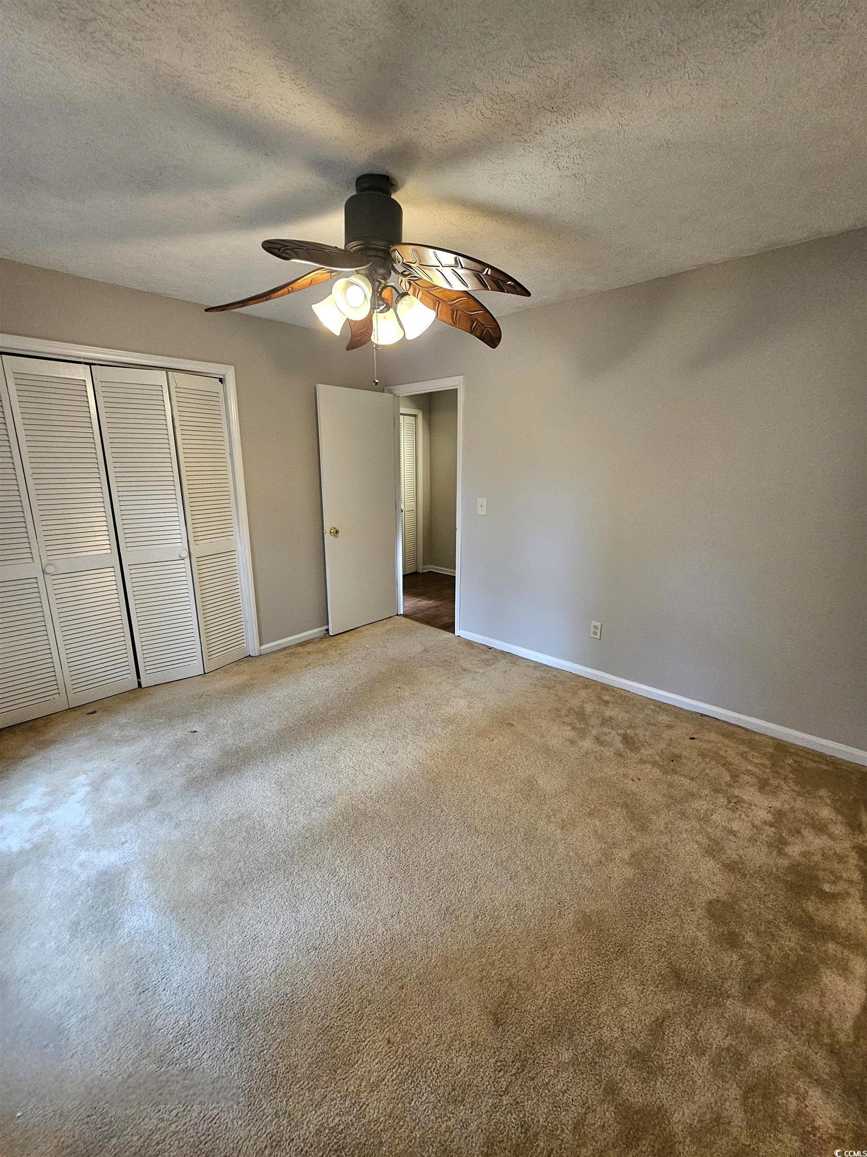 117 Partridge Berry Road Myrtle Beach, SC 29579 - Photo 24 of 33 Unfurnished bedroom with a closet, a textured ceiling, carpet floors, and ceiling fan