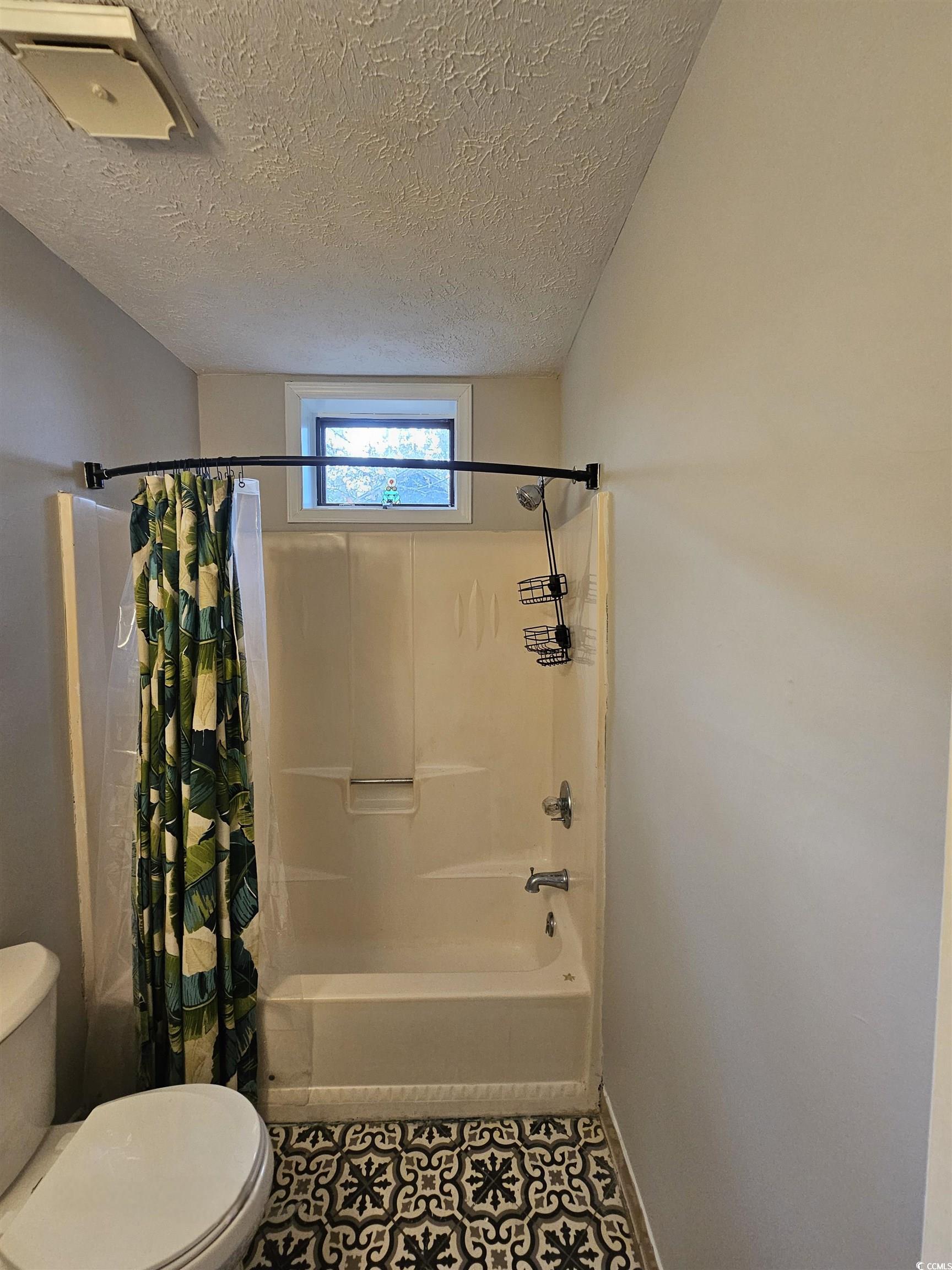 117 Partridge Berry Road Myrtle Beach, SC 29579 - Photo 26 of 33 Full bath featuring shower / bath combination with curtain, a textured ceiling, and tile patterned flooring