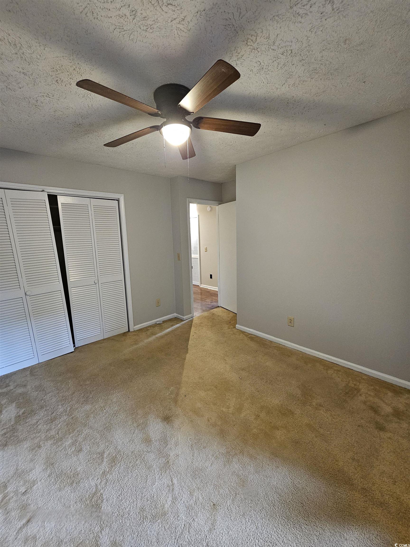117 Partridge Berry Road Myrtle Beach, SC 29579 - Photo 28 of 33 Unfurnished bedroom featuring a textured ceiling, a closet, carpet flooring, and a ceiling fan