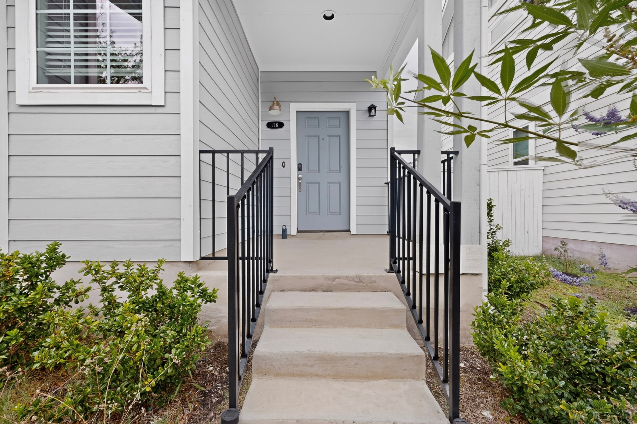 116 Appleberry Lane Elgin, TX 78621 - Photo 4 of 35 A welcoming front entry with gray siding and a light blue door beckons.