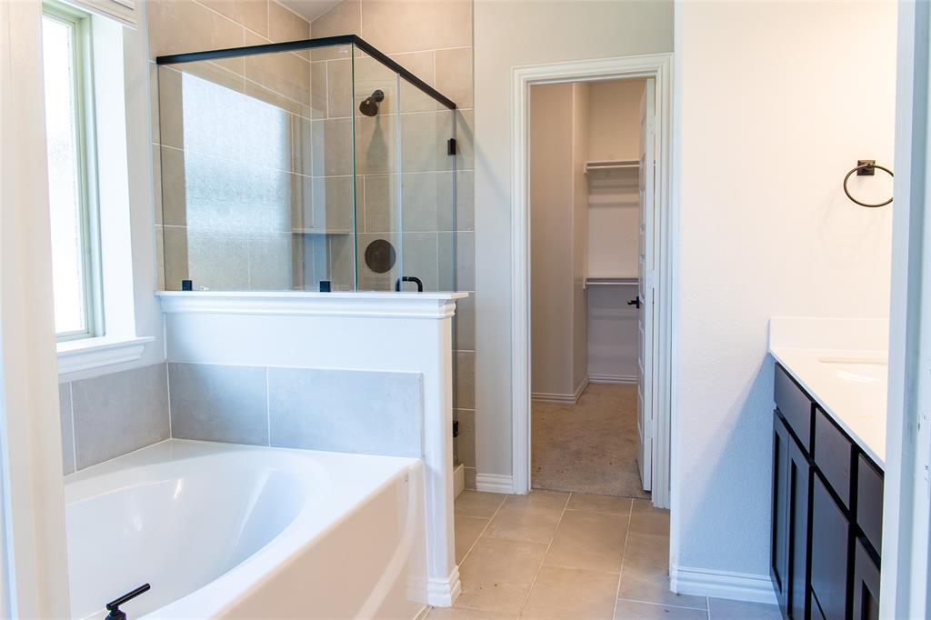 2604 Freeman Street Anna, TX 75409 - Photo 7 of 18 a bathroom with a tub sink and mirror