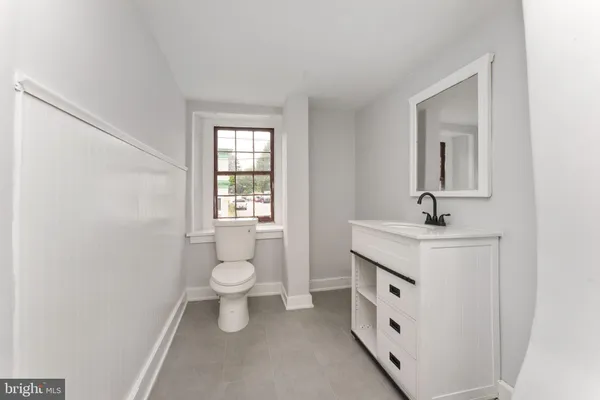 a bathroom with a toilet sink and mirror