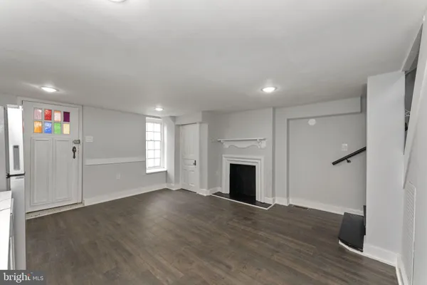 a view of empty room with wooden floor and fireplace