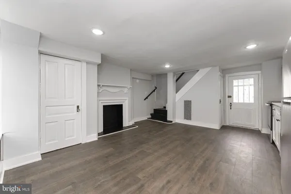 an empty room with windows and fireplace