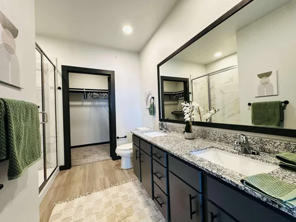 a spacious bathroom with a granite countertop sink and a mirror