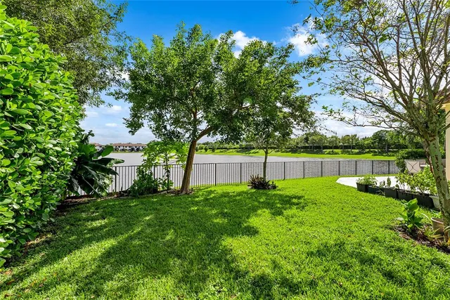 a view of a house with a yard and palm trees