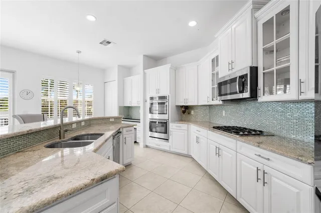 a kitchen with white cabinets and stainless steel appliances