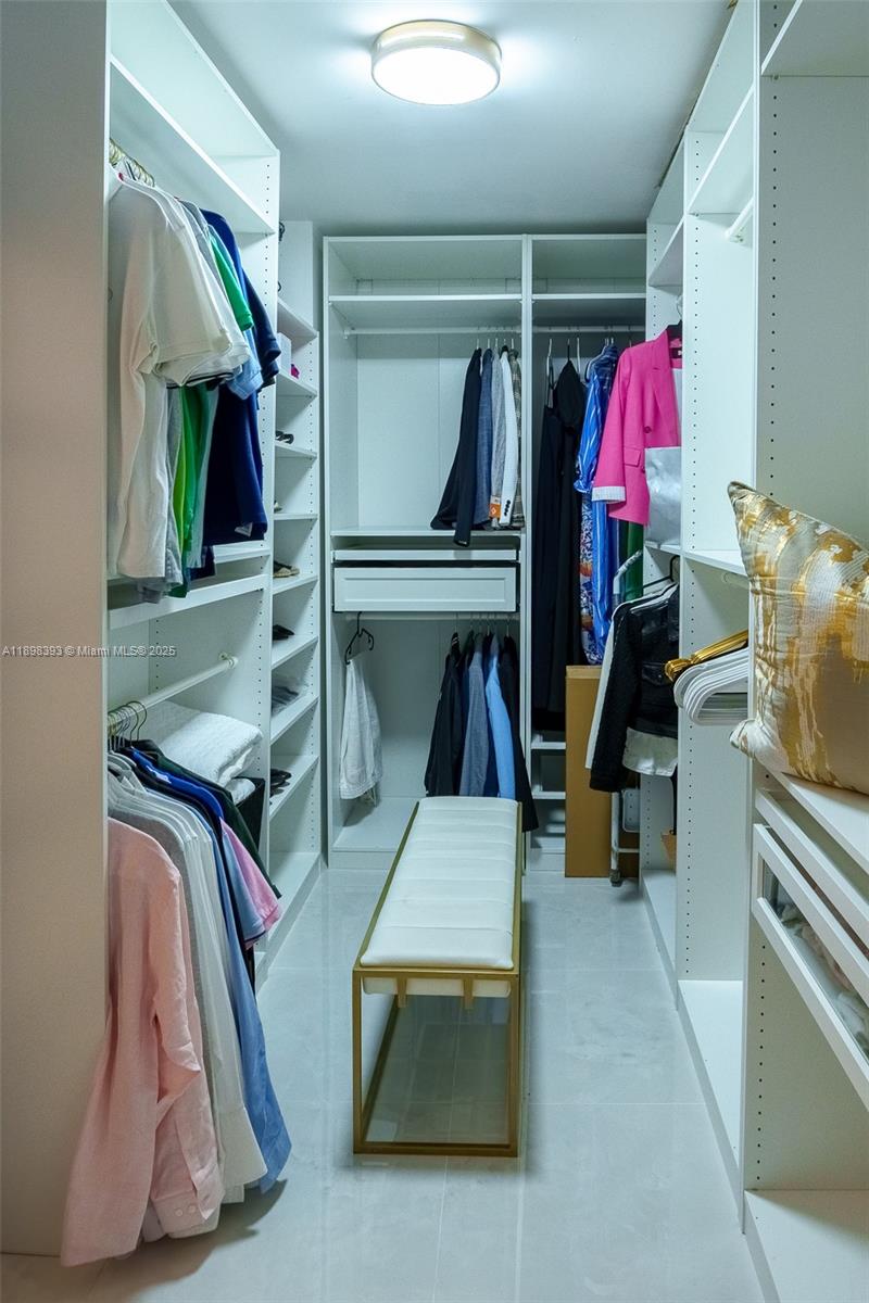 4000 Towerside Terrace, Unit 410 Miami, FL 33138 - Photo 17 of 74 a view of walk in closet with clothes and shoes
