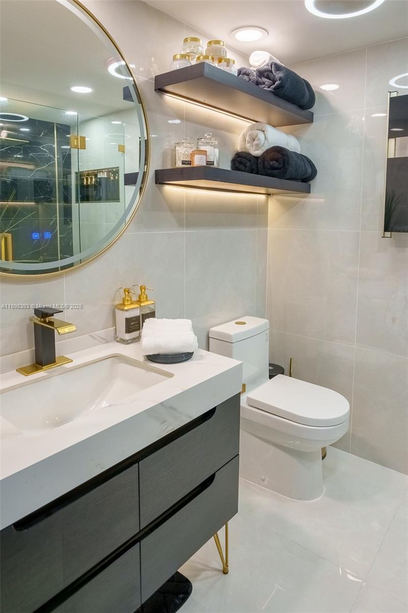 4000 Towerside Terrace, Unit 410 Miami, FL 33138 - Photo 25 of 74 a bathroom with a sink a toilet and a mirror