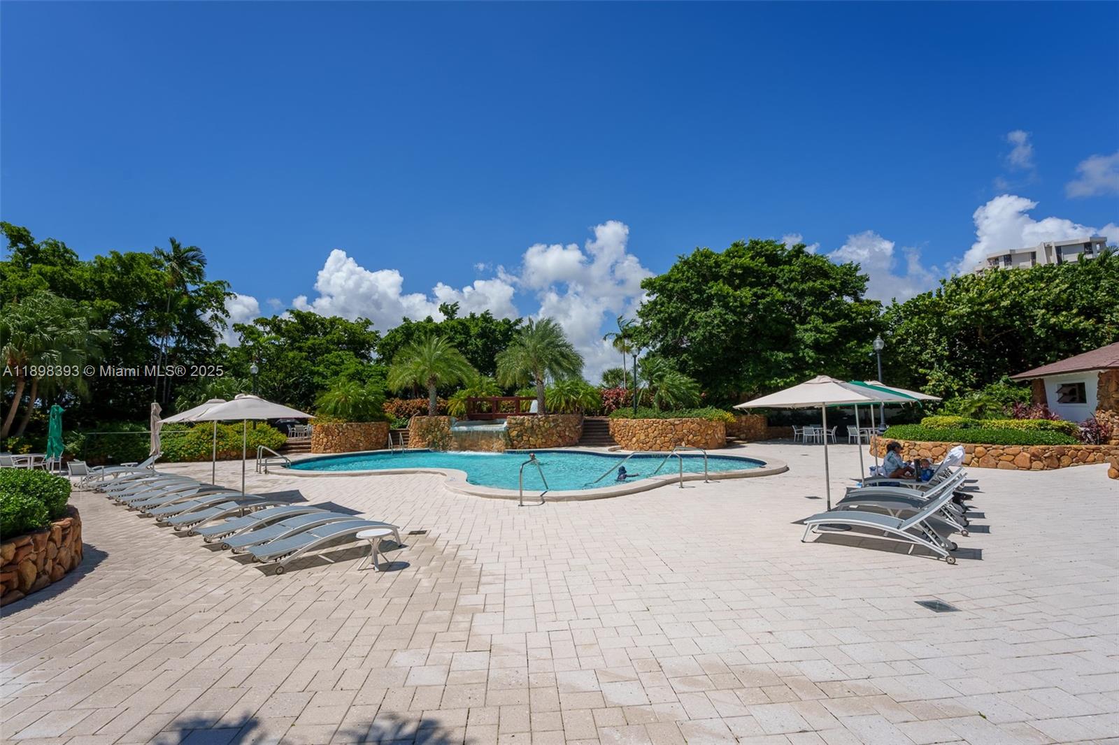 4000 Towerside Terrace, Unit 410 Miami, FL 33138 - Photo 36 of 74 a view of a swimming pool with lawn chairs under an umbrella