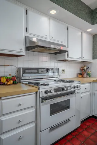 a kitchen with granite countertop stainless steel appliances and white cabinets