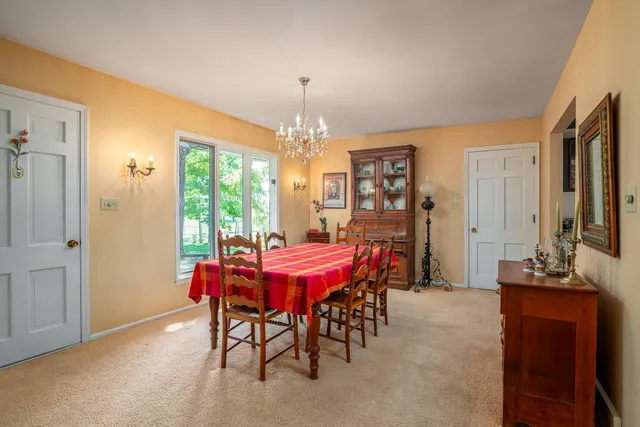 a dining room with furniture a chandelier and window