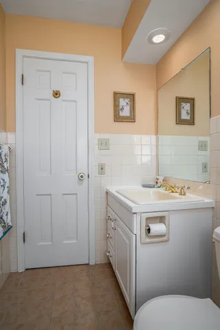 a bathroom with a sink a toilet and mirror