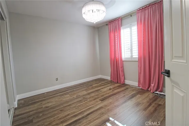 an empty room with a bed and a chandelier