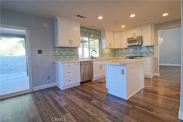 a kitchen with stainless steel appliances granite countertop a stove a sink and a refrigerator