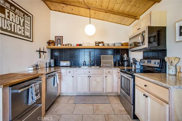 a kitchen with stainless steel appliances granite countertop a sink and dishwasher a stove top oven with a dishwasher