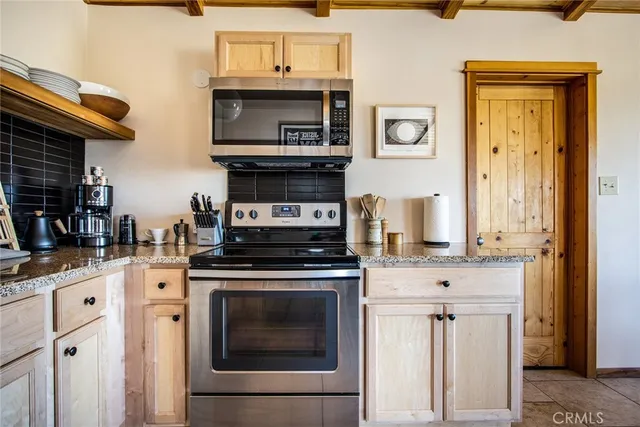 a kitchen with stainless steel appliances granite countertop a stove and a microwave