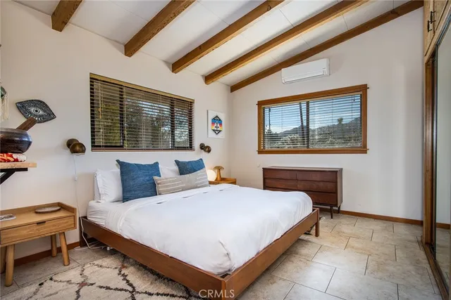 a bedroom with a bed and a dresser next to a window