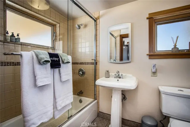 a bathroom with a sink mirror and tub