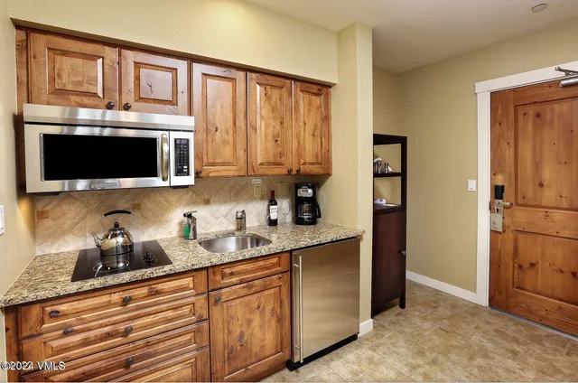a kitchen with stainless steel appliances granite countertop a refrigerator and microwave