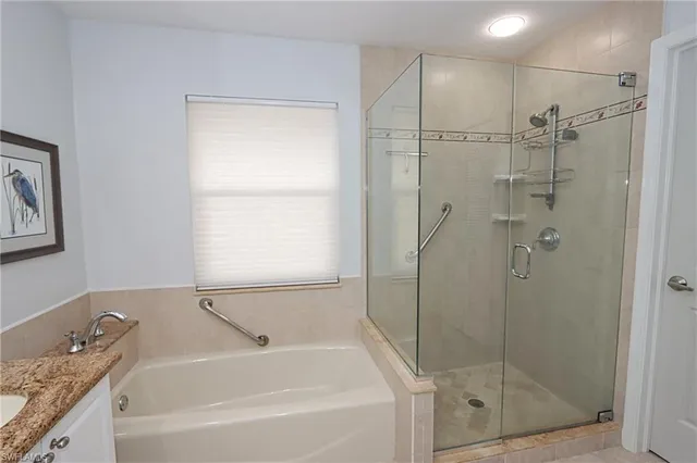 a bathroom with a granite countertop bathtub shower sink and vanity