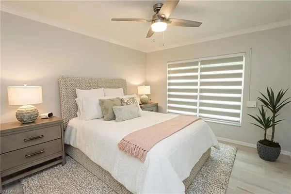a bedroom with a bed and a potted plant