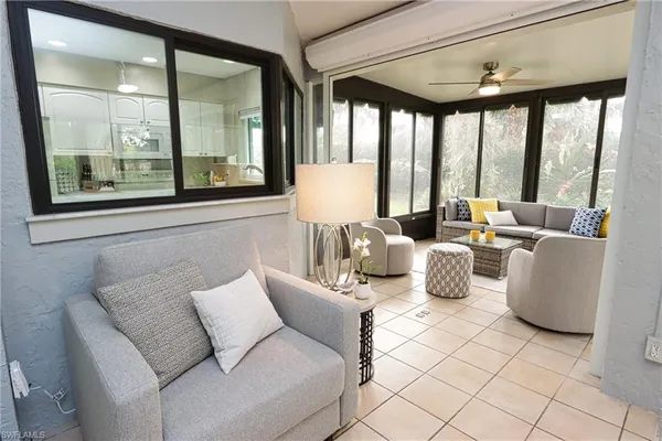 a living room with furniture and large windows