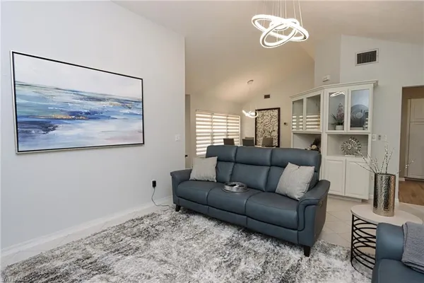 a living room with furniture and a painting on the wall