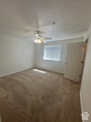 8196 North Cedar Springs Road, Unit 2 Eagle Mountain, UT 84005 - Photo 15 of 22 Unfurnished bedroom with carpet, a ceiling fan, and a textured ceiling
