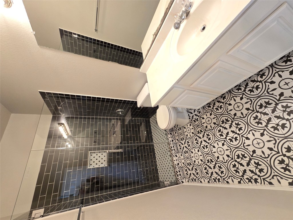 7509 Lazy Creek Drive, Unit B Austin, TX 78724 - Photo 13 of 20 Full bathroom with vanity, a shower stall, and a textured wall