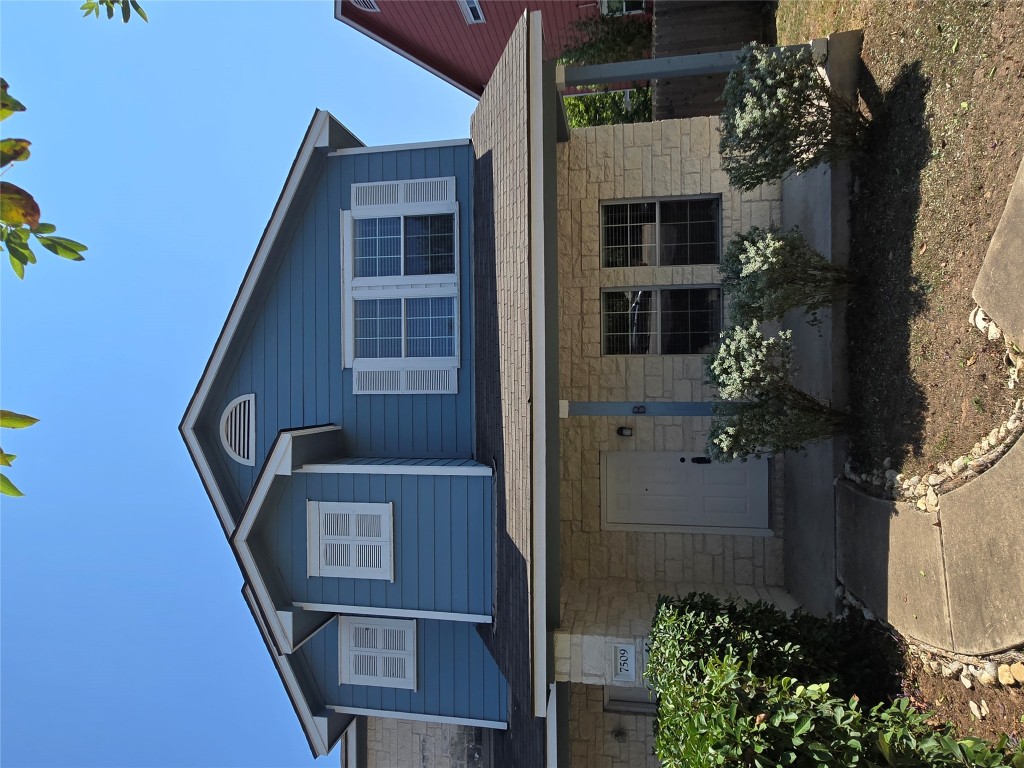 7509 Lazy Creek Drive, Unit B Austin, TX 78724 - Photo 20 of 20 View of front of house with stone siding, a porch, and a shingled roof