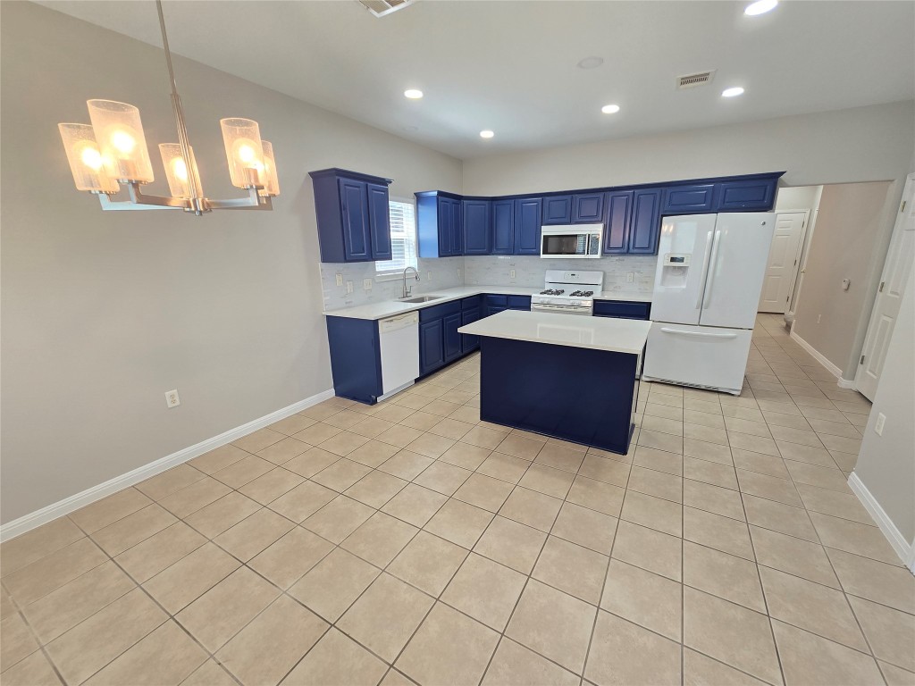 7509 Lazy Creek Drive, Unit B Austin, TX 78724 - Photo 2 of 20 Kitchen with blue cabinetry, white appliances, a center island, light tile patterned floors, and light countertops