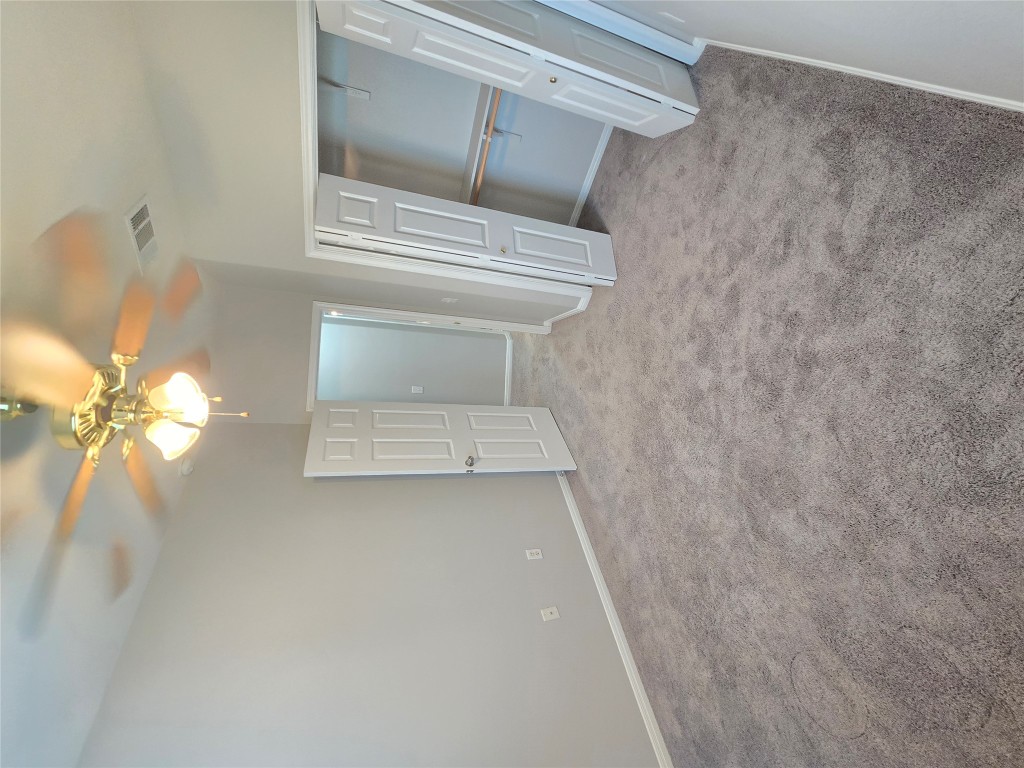 7509 Lazy Creek Drive, Unit B Austin, TX 78724 - Photo 9 of 20 Unfurnished bedroom featuring light carpet, a ceiling fan, and a closet