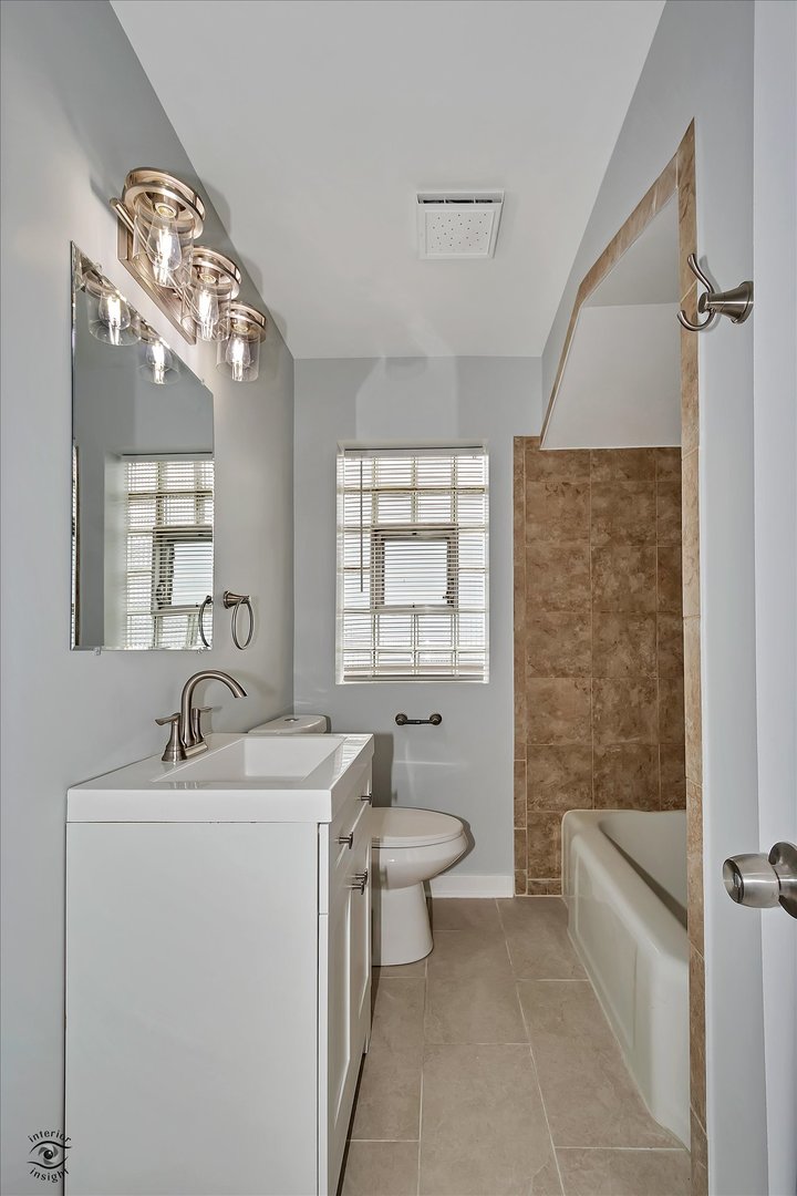 7229 57th Place Summit, IL 60501 - Photo 26 of 30 a bathroom with a double vanity sink toilet mirror and bathtub