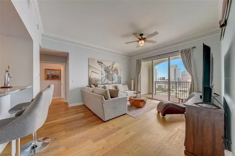 a living room with furniture large windows and flat screen tv