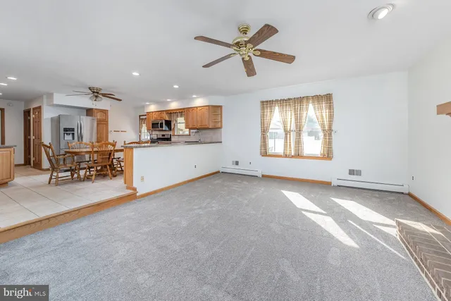 an empty room with windows and fireplace