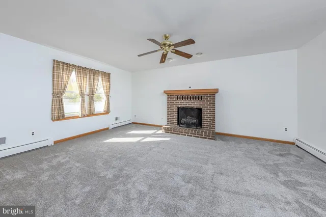 a living room with furniture a fireplace and a large window