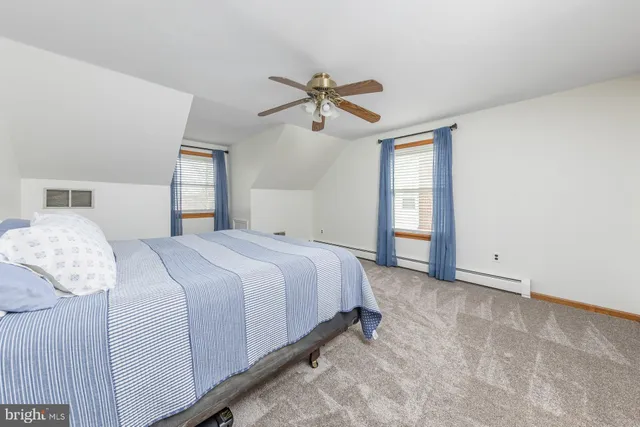 a spacious bedroom with a bed and a chandelier