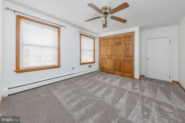 a bathroom with a granite countertop sink a toilet and mirror