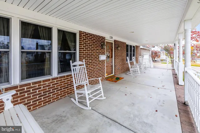 a view of a porch with furniture and floor to ceiling window