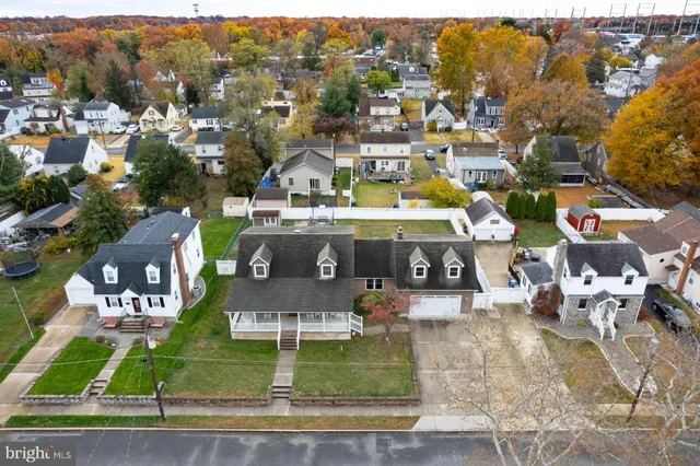 an aerial view of residential houses with outdoor space and parking
