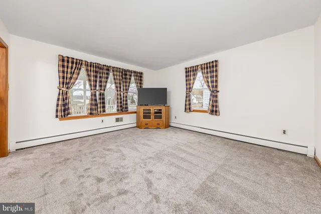 an empty room with furniture and flat screen tv