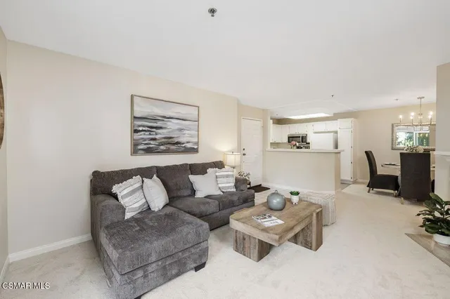 a living room with furniture a flat screen tv and kitchen area