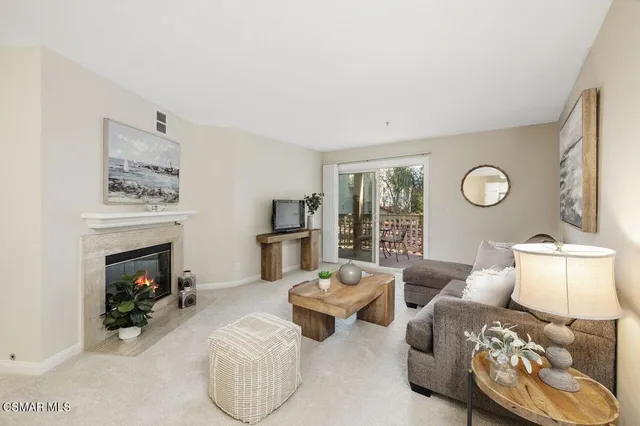 a living room with furniture a fireplace and a window