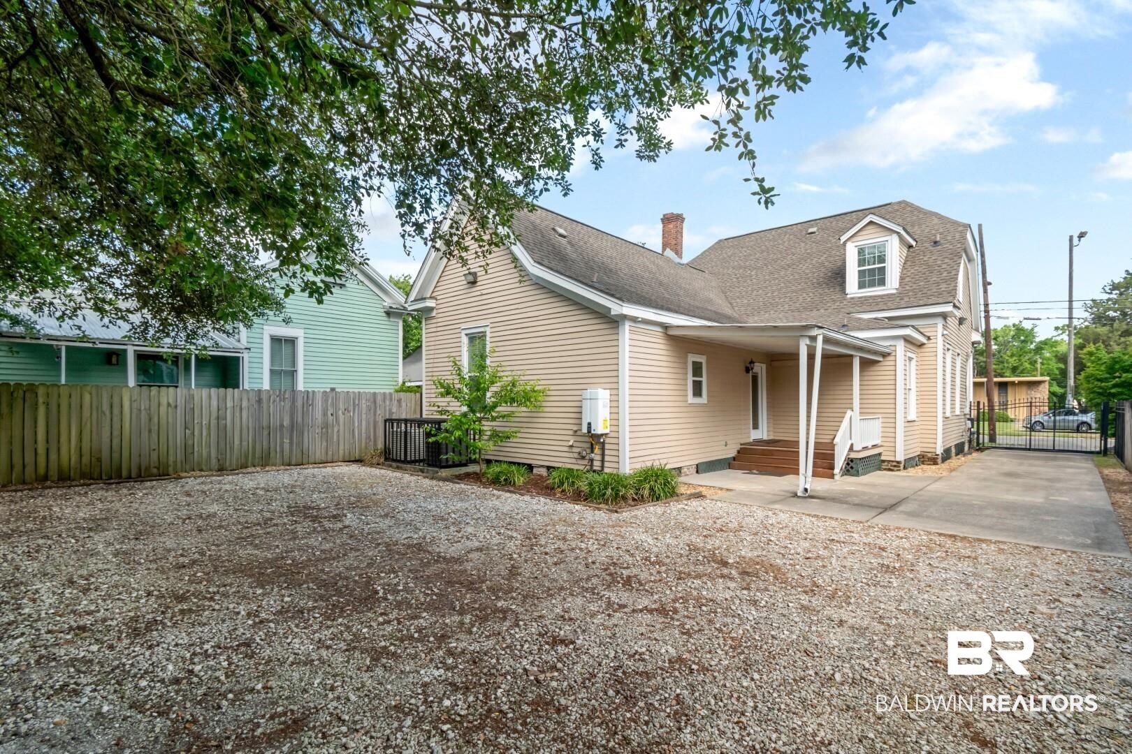 605 St Francis Street Mobile, AL 36602 - Photo 33 of 40 Back of property with fence, a shingled roof, a chimney, and driveway