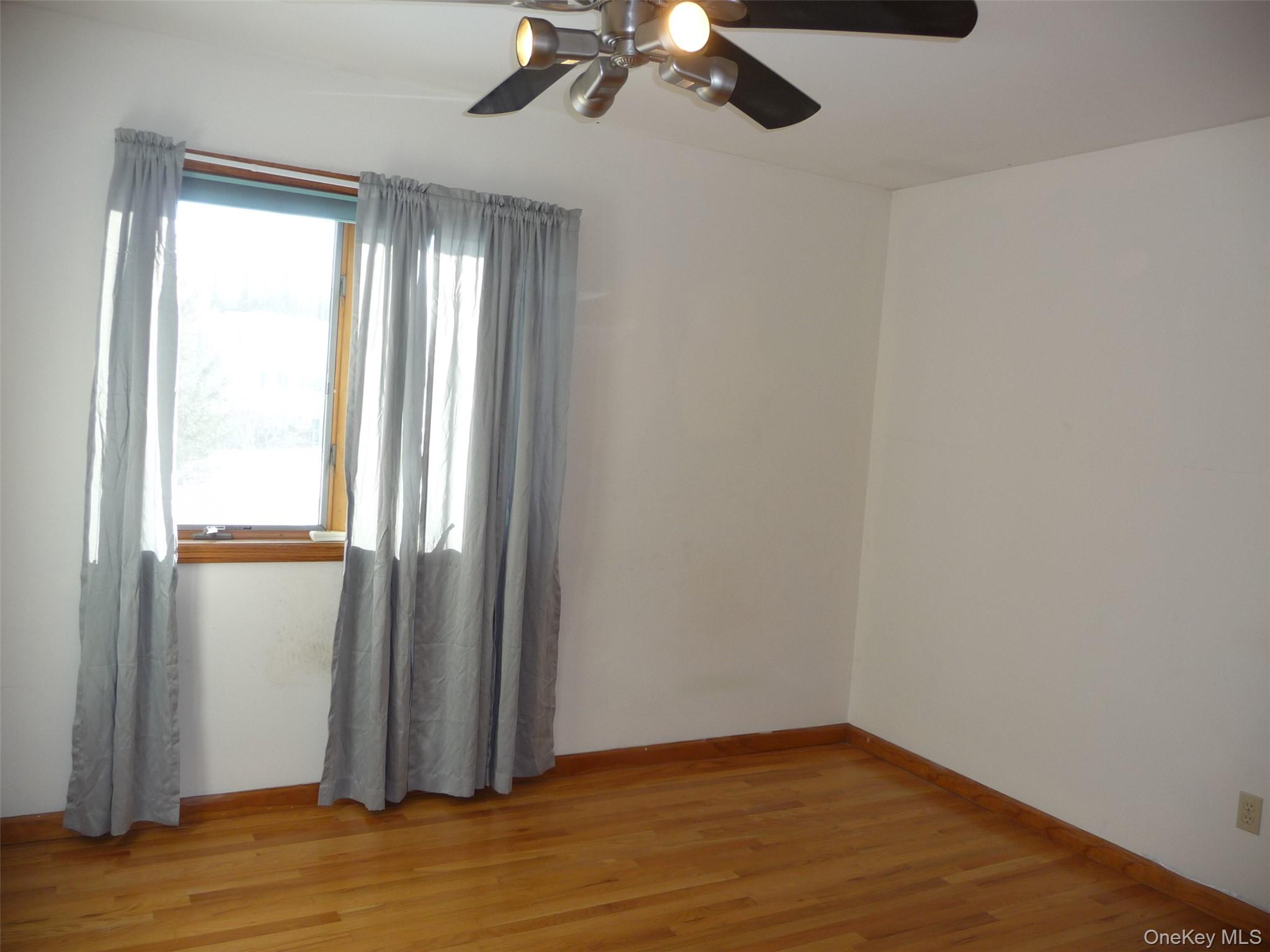 49 Lane Gate Road Wappingers Falls, NY 12590 - Photo 24 of 47 an empty room with wooden floor fan and windows