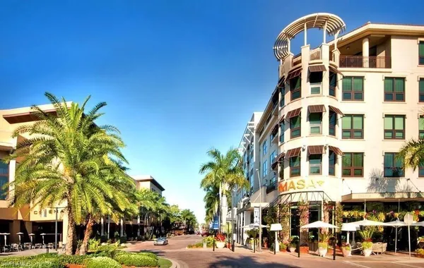 a front view of a building with a lot of plants and trees